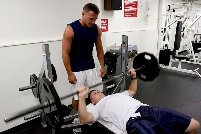 Lifter lying on a flat bench pressing a barbell